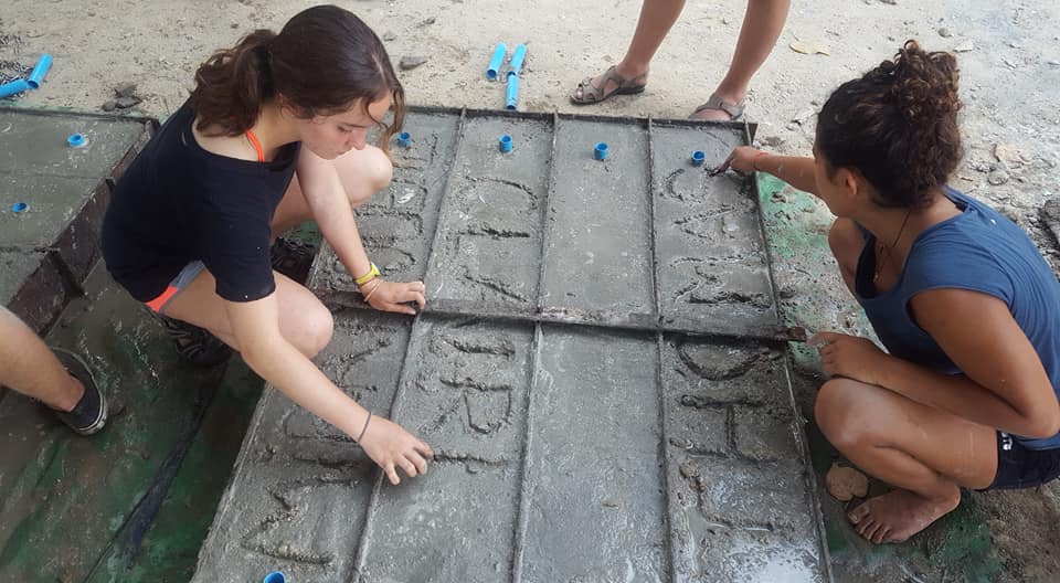 volunteers carving names in the blocks